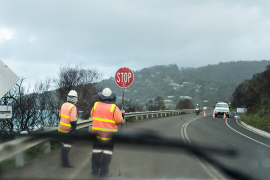 stop go workers on a stretch of highway, working on a cold, gloomy day.