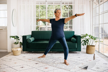 Warrior pose for seniors: Mature woman shows her strength and flexibility as she practices this...