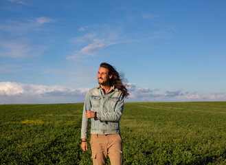 Long hair man in green meadow