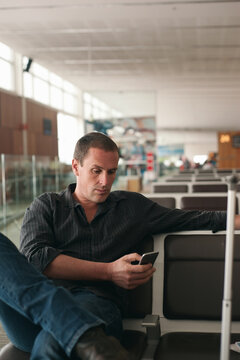 man using smartphone at an airport