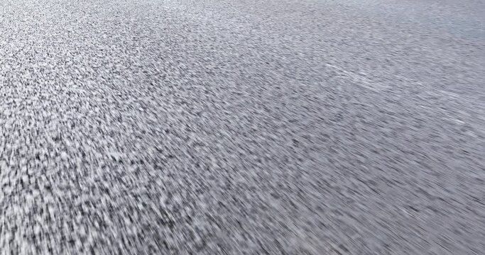 Close-up cinematic POV shot of an asphalt road. Car is driving on the highway.