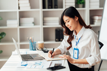 Young Asian Businesswomen smiling and happy used laptop working in the office.