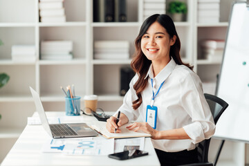 Young Asian Businesswomen smiling and happy used laptop working in the office.