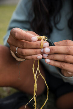 Close-up of an Aboriginal girl weaving threads, making baskets and bangles