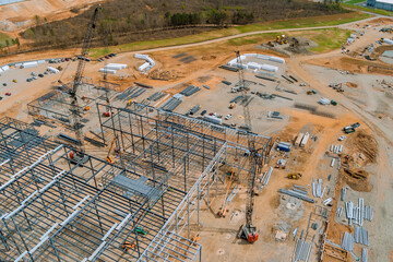 Cranes that are used to construct metal steel framing beams of steel for construction an industrial building