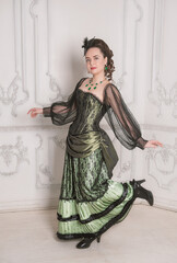 Beautiful young smiling woman wearing green medieval vintage Victorian Style dress dance