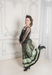 Beautiful young smiling woman wearing green medieval vintage Victorian Style dress dance