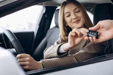 Woman sitting in car and taking car keys