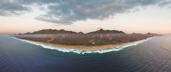 View from above, stunning panoramic view of Cofete beach surrounded by the chain of mountains of the Jandía Natural Park during a beautiful sunset. Fuerteventura, Canary Islands.