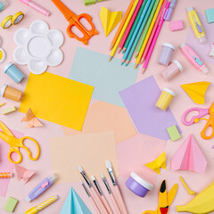 Pink pastel background with various colorful material for creativity and art activity.  Stationery and supplies for drawing and craft with .copy space.  Primary School or kindergarten.