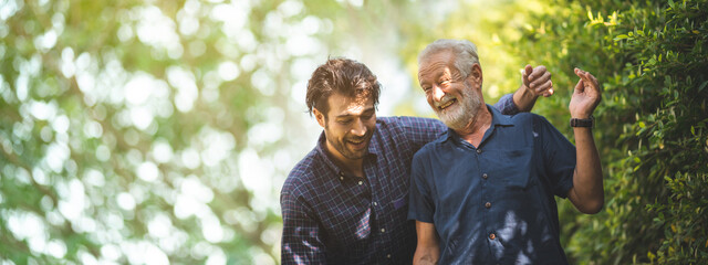 Adult hipster son fun hugging old senior father at home, two generations have a beard talking...