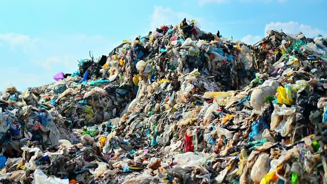View of a huge heap of plastic garbage at waste sorting plant, flies around. Slow motion