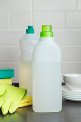 Blank plastic bottle with liquid dishwashing detergent on kitchen table