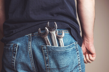 Man with wrenches in back pocket of his jeans. Ideal for industrial, mechanical, and DIY projects