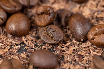 Roasted coffee beans lie together with chocolate crumbled into small pieces