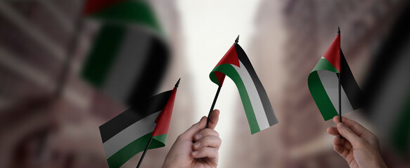 A group of people holding small flags of the Palestine in their hands