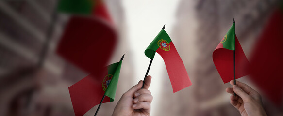 A group of people holding small flags of the Portugal in their hands