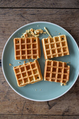 Fresh baked waffle in a pattern on wooden background, top view