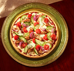 Pizza mit Gyros plus Gurke und Tomaten mit roten Zwiebeln