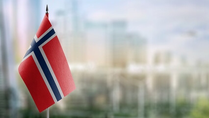Small flags of the Norway on an abstract blurry background