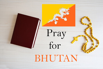 Pray for Bhutan. Rosary and Holy Bible background.