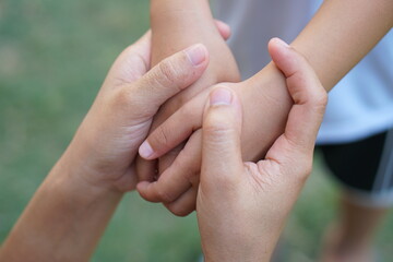 Mother holding son's hand to encourage and warm