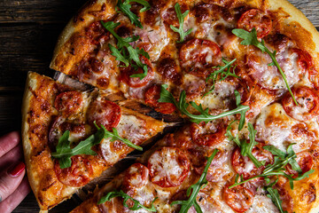 Appetizing pizza with ham on a wooden background