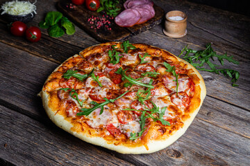 Appetizing pizza with ham on a wooden background