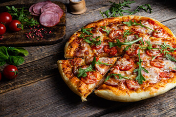 Appetizing pizza with ham on a wooden background