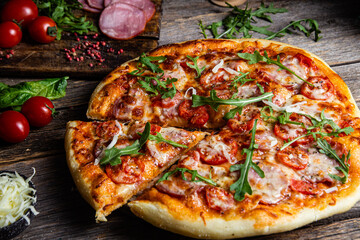 Appetizing pizza with ham on a wooden background