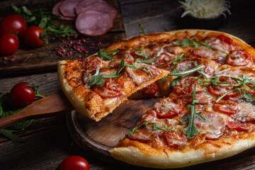 Appetizing pizza with ham on a wooden background