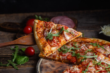 Appetizing pizza with ham on a wooden background