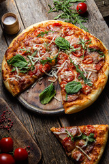 Appetizing pizza with ham on a wooden background