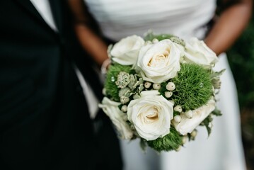 Bride holding a white wedding bouquet with blurred background
