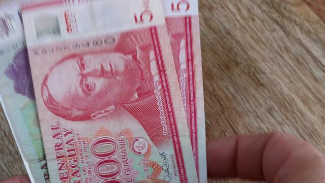 Paraguayan money counted in hand. Paragway currency, financial concept