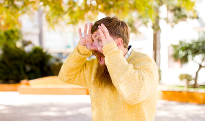 red hair bearded man keeping an eye on you, not trusting, watching and staying alert and vigilant