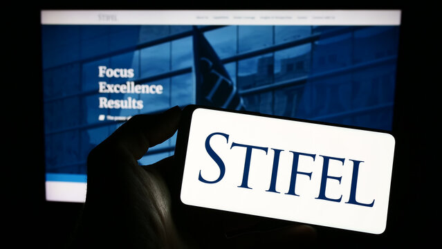 Stuttgart, Germany - 04-01-2023: Person holding cellphone with logo of American investment company Stifel Financial Corp. on screen in front of webpage. Focus on phone display.