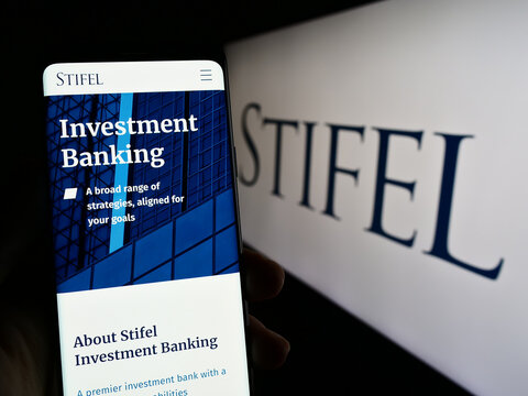 Stuttgart, Germany - 04-01-2023: Person holding cellphone with webpage of US investment company Stifel Financial Corp. on screen with logo. Focus on center of phone display.