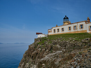 Fototapeta na wymiar Neist Point Lighthouse is sitting high on cliff.