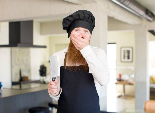 red hair man covering mouth with a hand and shocked or surprised expression. chef concept