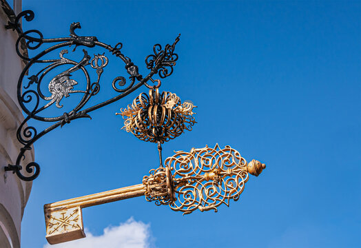 Copenhagen, Denmark - September 13, 2010: Wrought large Golden key above corner of Sankt Peders and Larslejsstraete, now a Thai Massage service, against blue sky