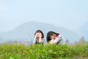 春の河川敷で遊ぶ幼い姉妹