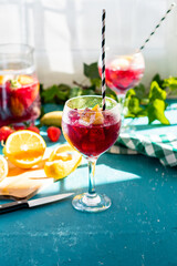 Sangría or tinto de verano, a refreshing drink typical of Spain with red wine, lemon, ice and fruit served in glasses, vertical photograph with background blur and copy space.