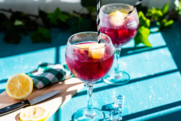 .Sangría or tinto de verano, a refreshing drink typical of Spain with red wine, lemon, ice and fruit served in glasses, with background blur and copy space.