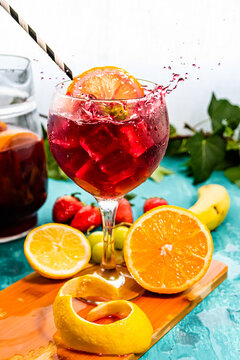 Sangria or tinto de verano, a refreshing drink typical of Spain with red wine, lemon, ice and fruit, photographed in crystal glasses, with cut fruit on the table and copy space..