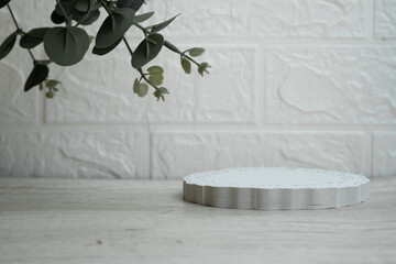 Abstract empty white podium with eucalyptus leaves on white background