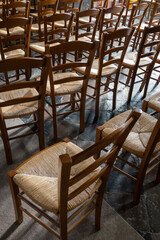 Rows of wooden chairs inside a medieval church in France