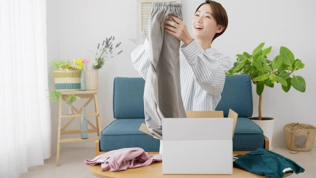 通信販売で衣類を売買する若い女性　ビジネスイメージ