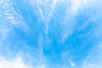 Beautiful white abstract cirrus clouds as if they diverging away from the center on blue sky.