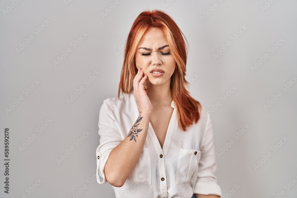 Poster Young caucasian woman standing over isolated background touching mouth with hand with painful expression because of toothache or dental illness on teeth. dentist